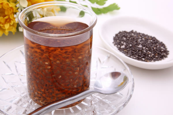 Vaso de agua con semillas de chía y una cuchara